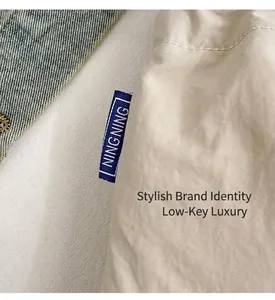 Macro detail of the cream nylon fabric with blue NINGNING woven label and texture