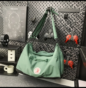 Detail of the light green nylon tote with durable black base and adjustable strap hardware