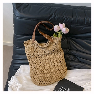 Close-up of hollowed-out straw weave texture and brown leather handle with metal rivets