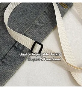 Detail of adjustable white nylon strap with black plastic buckle on denim crossbody bag