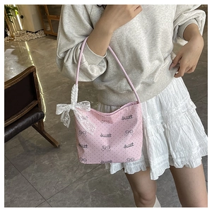 Dettaglio della borsa rosa a pois con fiocco in pizzo bianco e scritta dolce sweet