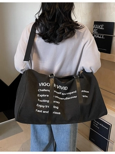 Large black canvas travel bag with white Vigour Vivid slogan and leather handles