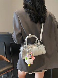 Fashionable silver bowling handbag with plush charm and crossbody strap for women