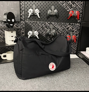 Detail of black nylon tote bag with side zipper and branded lunar logo patch