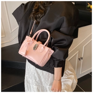 Detail of pink lychee leather bucket bag with silver metal lock and clochette charm
