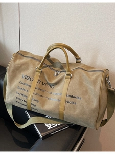 Olive canvas travel tote bag with leather handles and shoulder strap on a chair