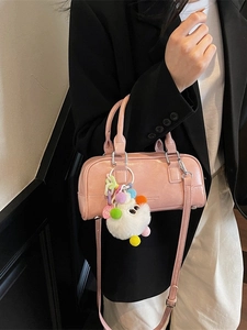 Pink glossy leather bowling handbag with plush charm and adjustable shoulder strap