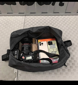 Sac de voyage à carreaux noir spacieux montrant l'espace pour caméra et électronique