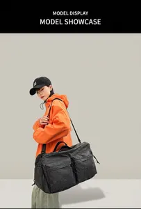 Détail du sac de voyage à damier noir avec poches frontales présenté par un mannequin