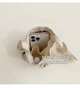 Interior view of nylon bucket bag showing spacious compartment with a smartphone