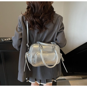 Detail of silver metallic textured tote bag with drawstring tassels and adjustable strap