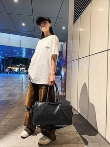Large black travel tote bag with ostrich embossed texture and detachable wide strap