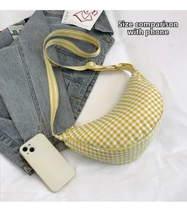 Detailed comparison showing yellow plaid crossbody bag size next to a smartphone
