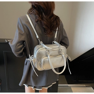 Silver metallic backpack with lychee texture and dual adjustable straps on female model