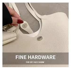 Macro view of high-quality silver magnetic clasp on cream lychee pattern leather bag