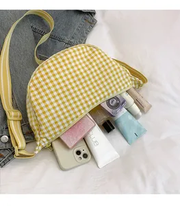 Spacious interior of yellow plaid crossbody bag showing storage for phone and cosmetics