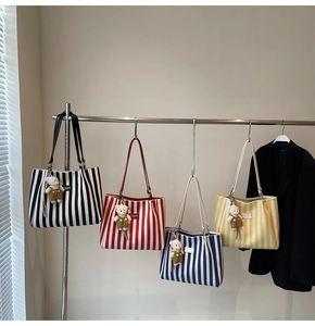 Détail de quatre sacs fourre-tout en toile à rayures avec des breloques ours mignons