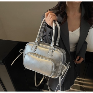 Macro shot of silver metallic textured PU leather bag with detailed zippers and handles