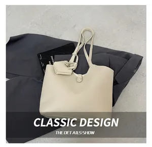 Detailed view of beige faux leather tote bag set with matching coin purse on dark backdrop