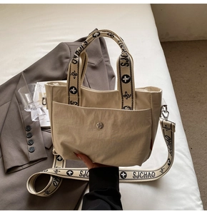 Detail der beigen Canvas-Tasche mit Jacquard-Gurtband und magnetischer Fronttasche