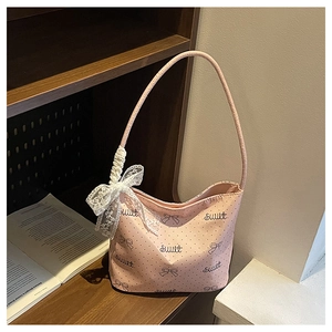 Borsa rosa a pois con scritte dolci e fiocco in pizzo bianco su uno scaffale di libri