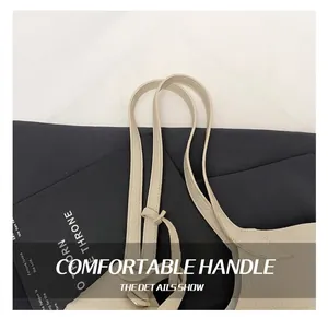 Detailed macro view of cream litchi texture leather handle on a large shoulder tote bag