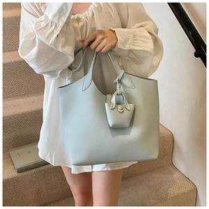 Close-up of light blue lychee pattern leather tote bag with a matching mini pouch charm