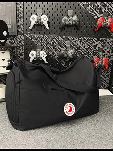 Large black nylon travel tote bag with shoulder strap and red round logo on front