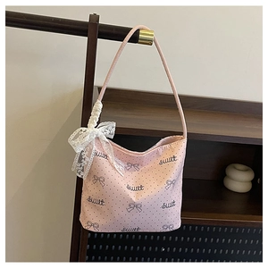 Dettaglio della borsa rosa a pois con stampa Sweet e fiocco in pizzo bianco