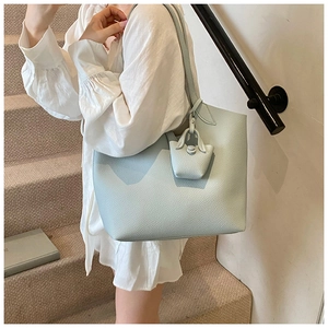 Detail of light blue tote bag with pebble leather texture and a matching mini charm