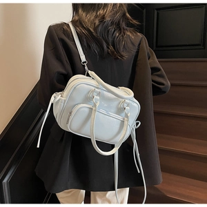 Detail of light blue textured PU leather bag with drawstring and front zip pocket