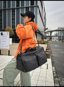 Détail du grand sac de voyage à carreaux avec poches zippées et poignées solides