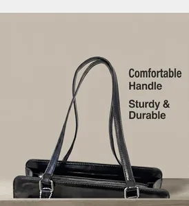Détail du sac cabas en cuir noir brillant avec des anses solides et ferrures argentées