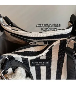 Détail de la fermeture éclair argentée sur le sac cabas en toile à rayures noires et blanches