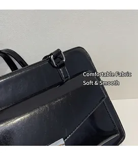 Gros plan du sac bandoulière en cuir verni noir avec boucle métallique et coutures