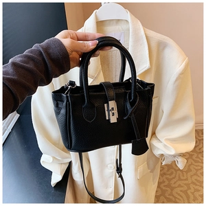 Detailed texture of black litchi pattern leather bag with silver metal swivel lock