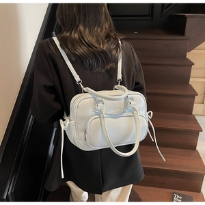 Detail view of light blue leather bag with drawstring side and silver metal hardware accents