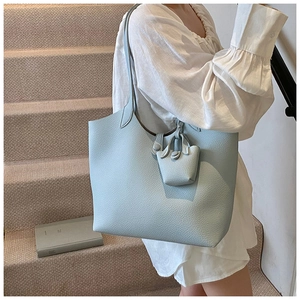 Close-up of light blue tote bag with lychee leather texture and mini pouch pendant