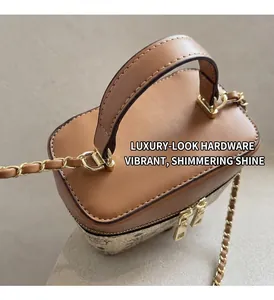 Detail of premium brown pebble leather handbag with polished gold chain strap hardware