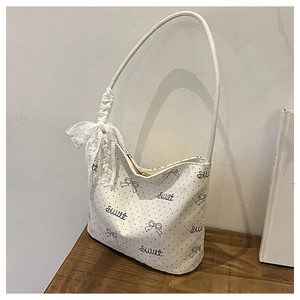 Dettaglio borsa a pois con stampa sweet e fiocco decorativo in pizzo bianco