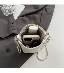 Vue intérieure du sac seau en cuir blanc cassé montrant la capacité pour smartphones