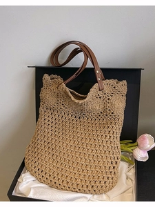 Straw woven tote bag with crochet floral pattern and brown leather handles in a gift box