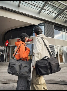 Détail de grands sacs de voyage avec deux poches zippées symétriques et des poignées solides