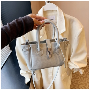 Close-up of light blue pebbled leather bucket bag featuring a silver metal twist lock