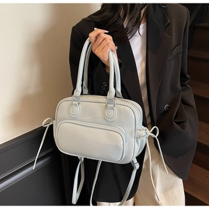 Detail showing mint blue PU leather texture and decorative side bow on the boston bag
