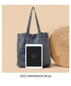 Detail of blue denim tote bag showing its interior capacity with a tablet device