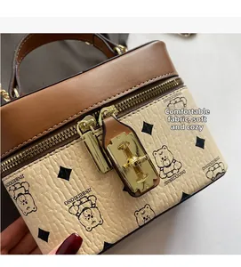 Close-up of dual zippers and golden hardware on a beige litchi texture bucket bag