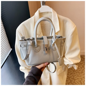Detail of light grey lychee pattern leather bucket bag with silver metal twist lock