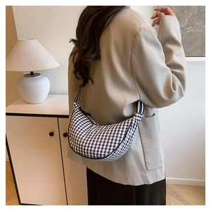 Detail of checkered crescent bag showing the black and white gingham pattern and strap