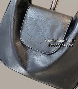 Detailed close-up of retro black shoulder bag showing pleated leather texture and fine stitching